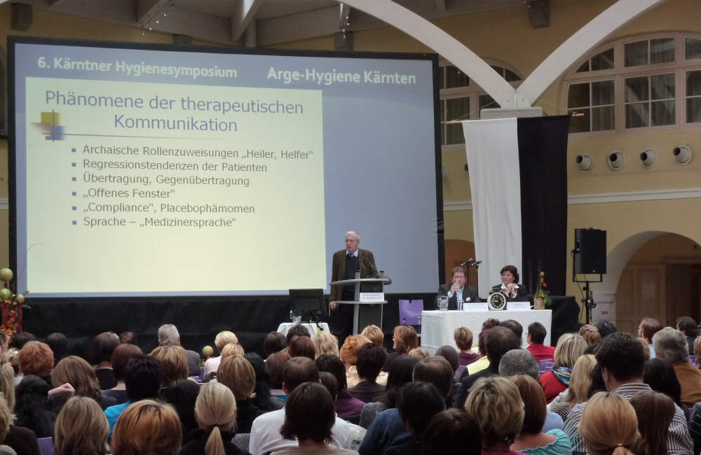 Bühne mit 6m breiter Rückprojektion, Rednerpult und Meyer Sound Lautsprecher auf Stativ im Krankenhaus Friesach