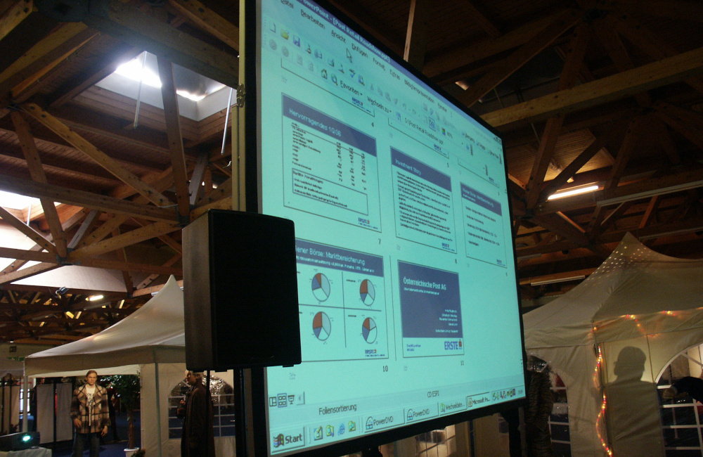 Videoprojektion auf Rückprojektionsleinwand und PA Lautsprecher auf Stativ in der Messehalle Klagenfurt