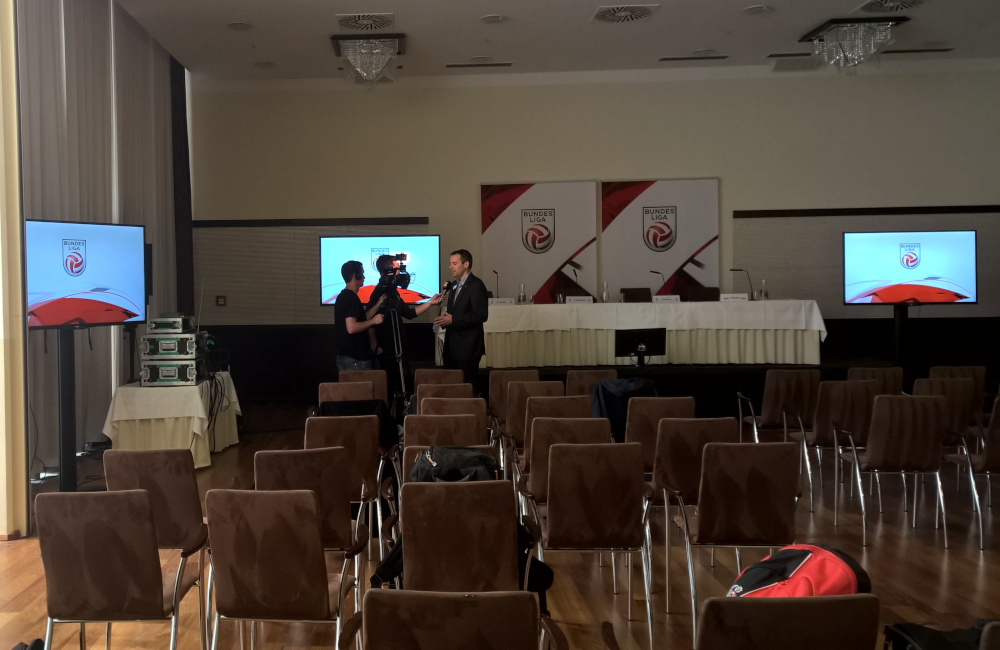 Bundesliga Pressekonferenz mit Bühne, Podium, Tischmikrofonen, Flat-TVs auf SMS Stativen in Klagenfurt Hotel Sandwirth