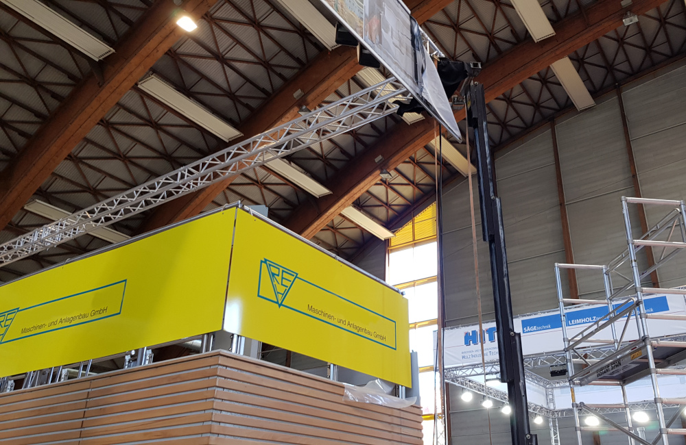 Rudnick & Enners Messestand auf der Holzmesse Klagenfurt, HQI Beleuchtung und Banner