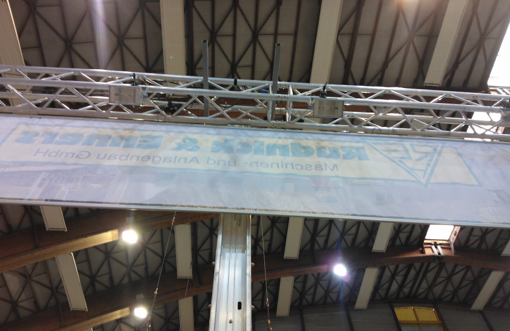 Rudnick & Enners Messestand Aufbau der Traversen, Banner und HQI Beleuchtung auf der Messe Holzbau in Klagenfurt
