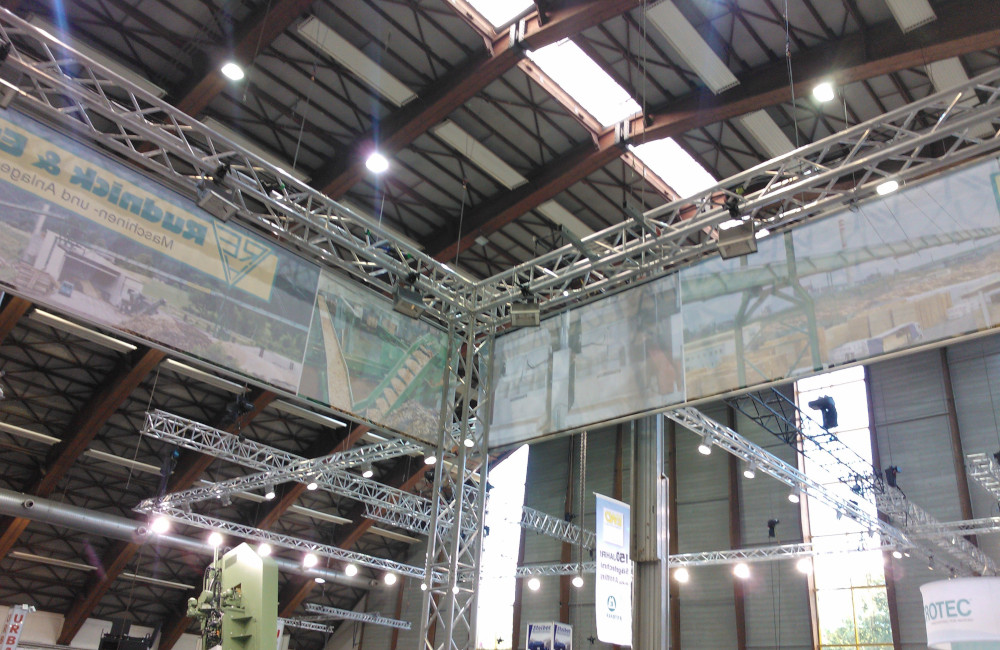 Rudnick & Enners Messestand Aufbau der Traversen, Banner und HQI Beleuchtung auf der Messe Holzbau in Klagenfurt