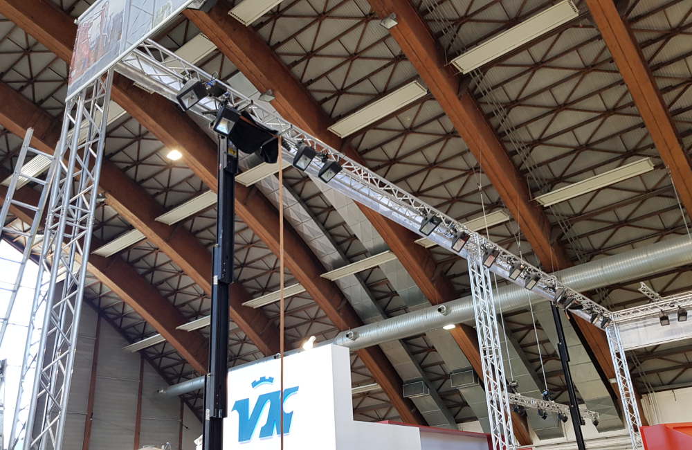 Rudnick & Enners Messestand Aufbau der Traversen, Banner und HQI Beleuchtung auf der Messe Holzbau in Klagenfurt