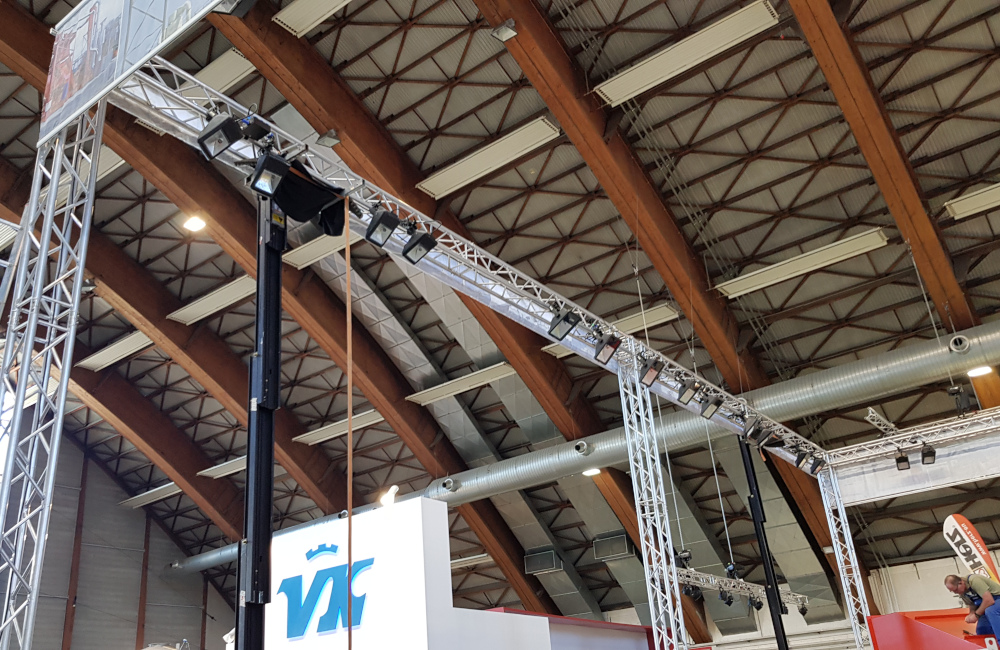 Messestand mit Traversensystem Banner Montage und HQI Beleuchtung für Rudnick und Enners Holzbau Messe Klagenfurt