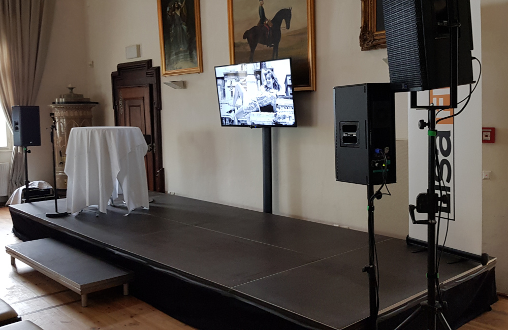 Bühne mit Stufe und Verkleidung, Meyer Sound Lautsprecher, Flat-TV für Lisafilm Buchpräsentation Schloss Loretto Klagenfurt