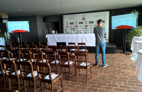 Pressekonferenz Bühne und Podium mit Schwanenhalsmikrofonen und seitlichen Flat TV's im Weingut Reisenberg Wien